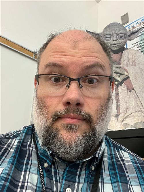Mr. Barnes in his classroom with Yoda in the background